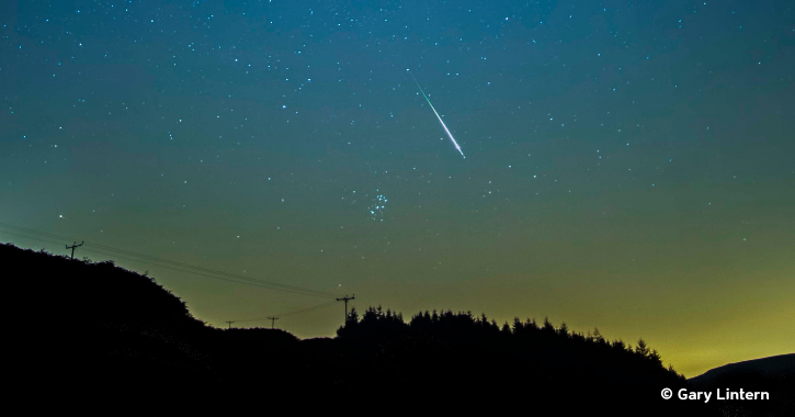 Meteor visible in night sky filled with stars over the Durham Dales.